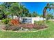 Welcome to Wilkinson Woods community sign, surrounded by colorful landscaping and lush greenery at 3549 Wilkinson Woods Dr # 38, Sarasota, FL 34231