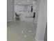 Bright living area leading to the kitchen, featuring gray tile flooring and neutral paint at 361 Yorkshire St, Port Charlotte, FL 33954