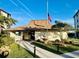 Charming clubhouse with an American flag, a fountain, and well-manicured landscaping at 3630 Gulf Of Mexico Dr # 304, Longboat Key, FL 34228