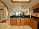 Well-appointed kitchen with wood cabinetry, granite countertops, and an open layout to the living room at 3630 Gulf Of Mexico Dr # 304, Longboat Key, FL 34228
