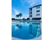 Inviting community pool with comfortable lounge chairs and a view of the condo building at 3630 Gulf Of Mexico Dr # 304, Longboat Key, FL 34228
