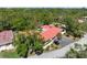 Aerial view of the home with a red tile roof surrounded by lush trees at 3804 Sun Eagle Ln, Bradenton, FL 34210