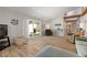 Bright living room with wood-look tile flooring, a vaulted ceiling and large sliding glass doors at 3804 Sun Eagle Ln, Bradenton, FL 34210