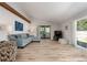 Bright living room with wood-look tile flooring, a vaulted ceiling and large sliding glass doors at 3804 Sun Eagle Ln, Bradenton, FL 34210