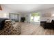 Inviting living room with wood-look tile flooring, neutral walls and patio access with natural light at 3804 Sun Eagle Ln, Bradenton, FL 34210