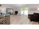 Comfortable living room featuring wood-look tile flooring, neutral walls and large sliding glass doors at 3804 Sun Eagle Ln, Bradenton, FL 34210