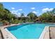 Community pool with blue lounge chairs surrounded by tropical landscaping at 3804 Sun Eagle Ln, Bradenton, FL 34210