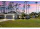 Charming single-story home with a well-maintained lawn and a screened garage, all under a beautiful sunset sky at 3865 N Cranberry Blvd, North Port, FL 34286