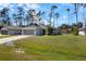 Well-maintained single-story home with a lush green lawn, mature trees, and a storage shed in the backyard at 3865 N Cranberry Blvd, North Port, FL 34286