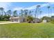 Home with a neatly kept lawn, and lush trees on a sunny day at 3865 N Cranberry Blvd, North Port, FL 34286