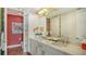 Elegant bathroom featuring double sinks, granite countertops, a vanity with storage, and a decorated mirror at 388 Aruba Cir # 201, Bradenton, FL 34209