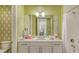 Well-lit bathroom with a white vanity, stylish fixtures, turtle-themed wallpaper, and a marble-tiled shower at 388 Aruba Cir # 201, Bradenton, FL 34209