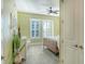 Comfortable bedroom featuring light green walls, plantation shutters, and ceiling fan at 388 Aruba Cir # 201, Bradenton, FL 34209