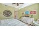 Bedroom with green accents, shutters, dresser with TV, and decorative lighting at 388 Aruba Cir # 201, Bradenton, FL 34209