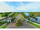 Scenic entrance to a community with a gate, palm-lined street, and a lake reflecting the clear sky at 388 Aruba Cir # 201, Bradenton, FL 34209