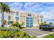 Exterior of a large building with a blue and white facade, surrounded by lush landscaping and palm trees at 388 Aruba Cir # 201, Bradenton, FL 34209
