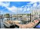 A view of various boats docked in a marina, with modern buildings and lush greenery in the background at 388 Aruba Cir # 201, Bradenton, FL 34209