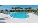 Stunning pool area surrounded by lounge chairs, palm trees, and serene water views at 388 Aruba Cir # 201, Bradenton, FL 34209