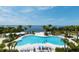Aerial view of a large pool with lounge chairs, palm trees, and breathtaking ocean scenery at 388 Aruba Cir # 201, Bradenton, FL 34209