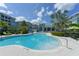 Gorgeous community pool and lounging area, surrounded by verdant landscaping and comfortable patio furniture at 388 Aruba Cir # 201, Bradenton, FL 34209