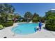 Resort-style pool offers a refreshing escape with tropical landscaping, lounge chairs, and vibrant umbrellas at 388 Aruba Cir # 201, Bradenton, FL 34209