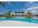 Exterior view of a beautiful pool, beachfront building, palm trees, and blue skies at 388 Aruba Cir # 201, Bradenton, FL 34209