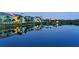 Beautiful water view of townhomes reflecting on a calm lake at twilight, enhanced by palm trees and serene colors at 388 Aruba Cir # 201, Bradenton, FL 34209