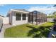 A beautifully maintained backyard with manicured lawn and a screened-in patio with a hot tub at 3926 Sunshine Pine Ave, Bradenton, FL 34203