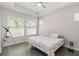 Comfortable bedroom featuring two windows, tray ceiling, and gray toned flooring at 3926 Sunshine Pine Ave, Bradenton, FL 34203