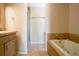 Bright bathroom featuring a shower, tub with tile surround, and neutral-toned tile flooring at 401 27Th W St, Bradenton, FL 34205