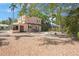 Back exterior view of home features gravel yard and mature trees at 401 27Th W St, Bradenton, FL 34205