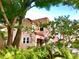 Charming two-story home featuring stucco walls, a red tile roof, and lush tropical landscaping at 401 27Th W St, Bradenton, FL 34205