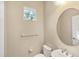 A well-lit bathroom offers a round mirror above the sink, complementing the room's neutral tones at 4015 Celestial Blue Ct, Bradenton, FL 34211