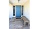 Inviting front entrance featuring a vibrant blue door and bench seating on a tiled porch at 41 Young Ave, Englewood, FL 34223