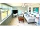 Bright living room with a ceiling fan, white couch, and large windows at 41 Young Ave, Englewood, FL 34223