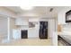 Open kitchen design with white cabinets, stainless steel appliances, tile floor, and serving window to other spaces at 4201 Center Gate Ln # 1, Sarasota, FL 34233