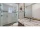 Stylish bathroom features a glass shower, tiled walls, granite vanity, and decorative mirror at 551 Ranger Ln, Longboat Key, FL 34228
