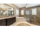 Luxurious bathroom with a soaking tub, glass-enclosed shower, and granite countertops at 551 Ranger Ln, Longboat Key, FL 34228