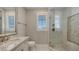 Elegant bathroom features a glass shower enclosure, a marble vanity, and bright natural light at 551 Ranger Ln, Longboat Key, FL 34228