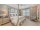 Cozy bedroom featuring a four poster bed, neutral walls, and a bright window with shutters at 551 Ranger Ln, Longboat Key, FL 34228