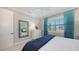 Bright bedroom featuring a coastal decor, large window with shutters, and ensuite bathroom at 551 Ranger Ln, Longboat Key, FL 34228