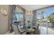 Elegant dining room featuring a glass table, stylish chairs, chandelier, and views of the outdoors at 551 Ranger Ln, Longboat Key, FL 34228