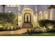 Grand entrance featuring a wrought iron door, manicured landscaping, and brick stairs at 551 Ranger Ln, Longboat Key, FL 34228