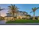 Elegant home with a lush lawn, mature palms, and a two-car garage showcased at dusk at 551 Ranger Ln, Longboat Key, FL 34228