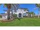 Luxurious two-story home featuring elegant landscaping, a manicured lawn, and a grand front entrance at 551 Ranger Ln, Longboat Key, FL 34228