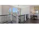 Bright hallway features dark wood flooring and decorative wrought iron railings at 551 Ranger Ln, Longboat Key, FL 34228