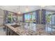 Open kitchen layout featuring an oversized kitchen island and dining area with water views at 551 Ranger Ln, Longboat Key, FL 34228