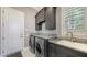 Efficient laundry room has front load washer/dryer and granite countertops at 551 Ranger Ln, Longboat Key, FL 34228