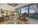 A living room with luxury furniture opens to a pool area and has views of a canal at 551 Ranger Ln, Longboat Key, FL 34228