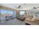 Spacious living room with a large sofa, ceiling fans, area rug, and access to a balcony with water views at 551 Ranger Ln, Longboat Key, FL 34228